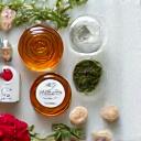 Boccette e flaconi di prodotti di bellezza naturali con petali di fiori e foglie